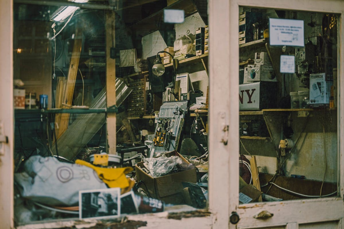 Cluttered garage with tools and stored items awaiting clearance